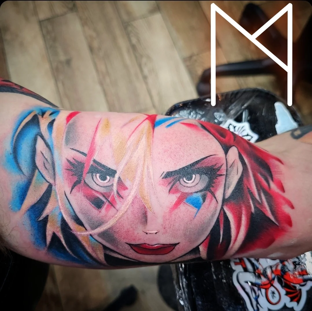 Vibrant color realism Harley Quinn portrait tattoo on forearm