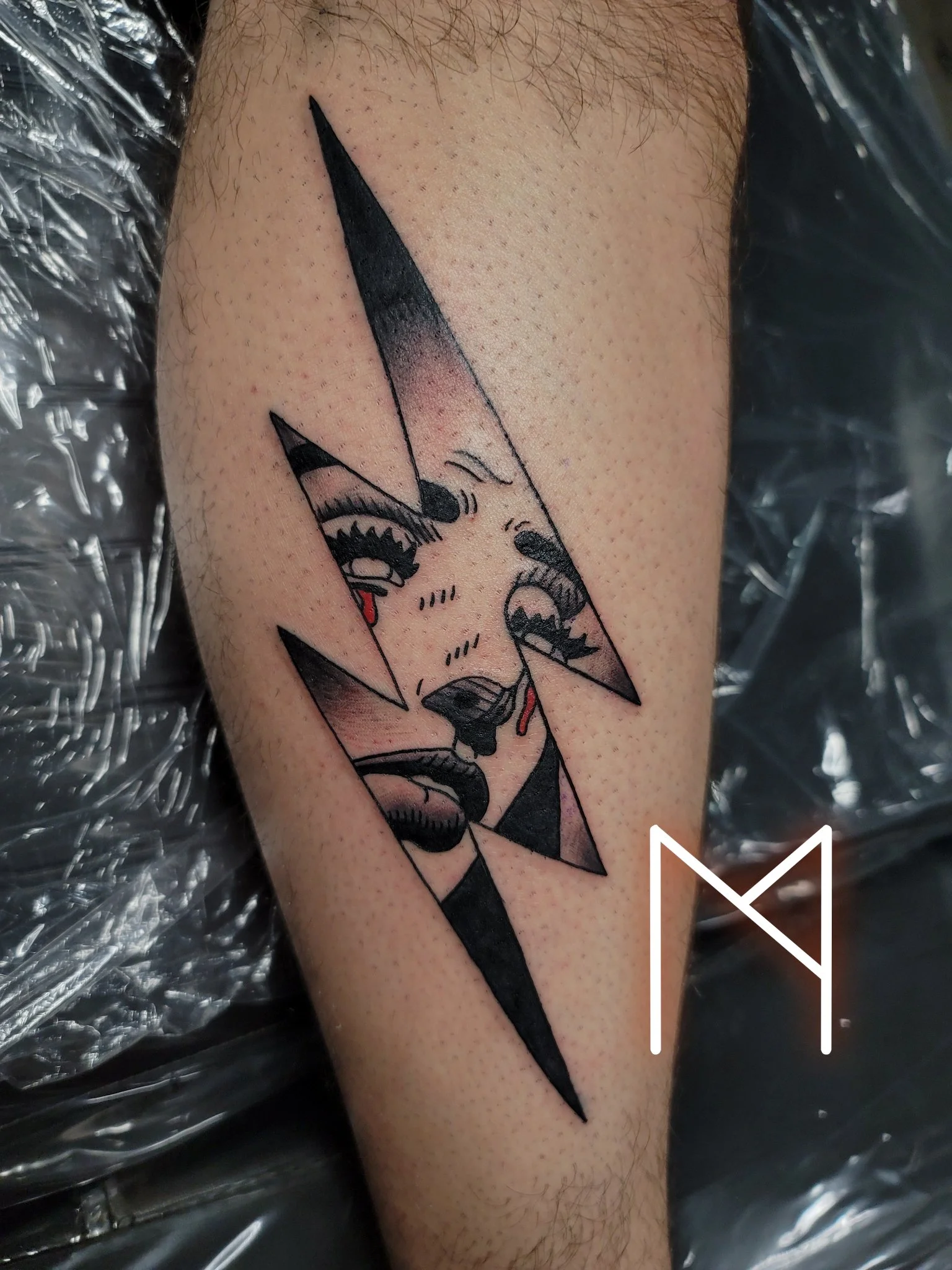 Neo-traditional crying face within lightning bolt on lower leg
