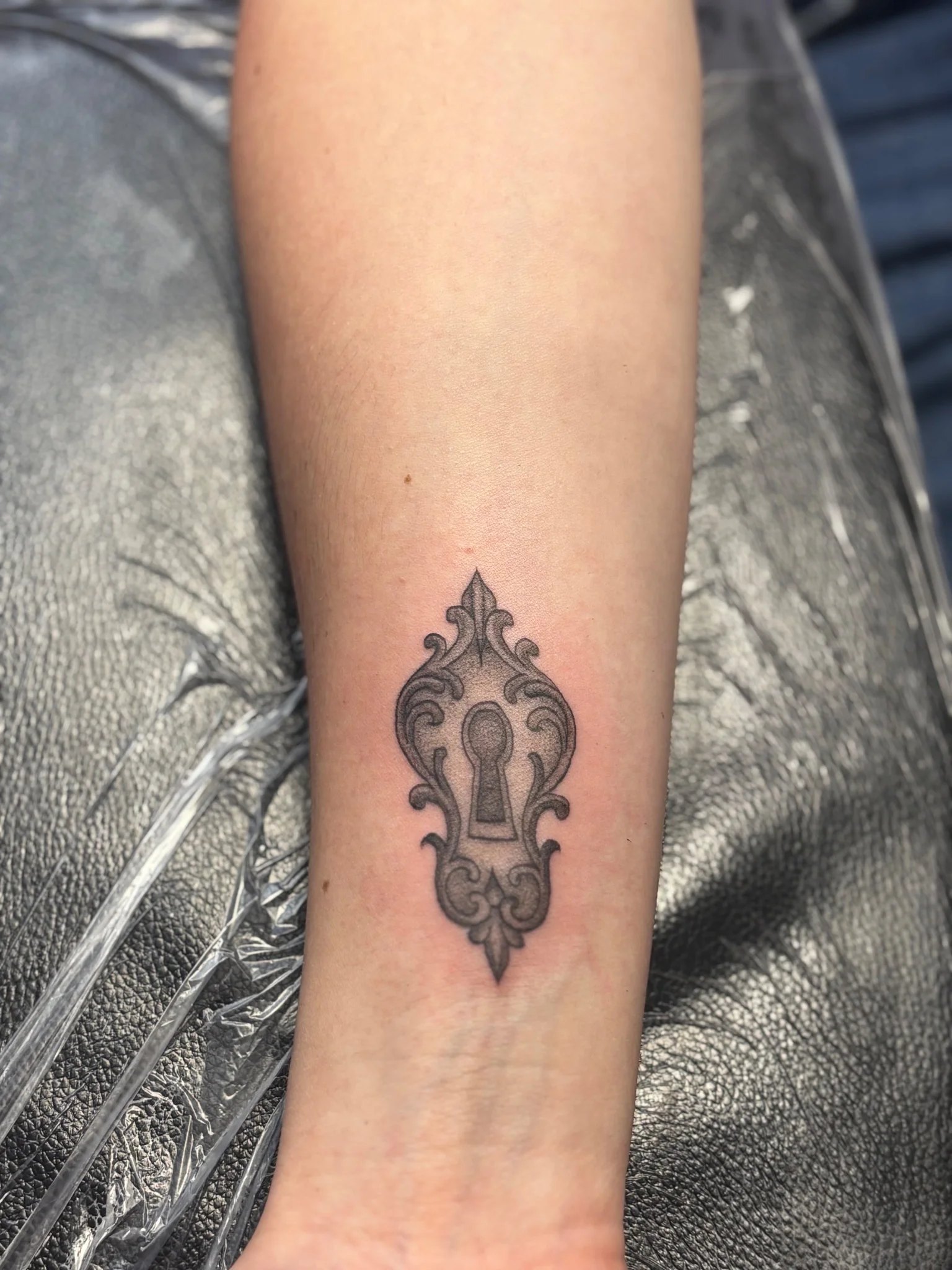 Ornamental Victorian keyhole filigree tattoo on inner forearm