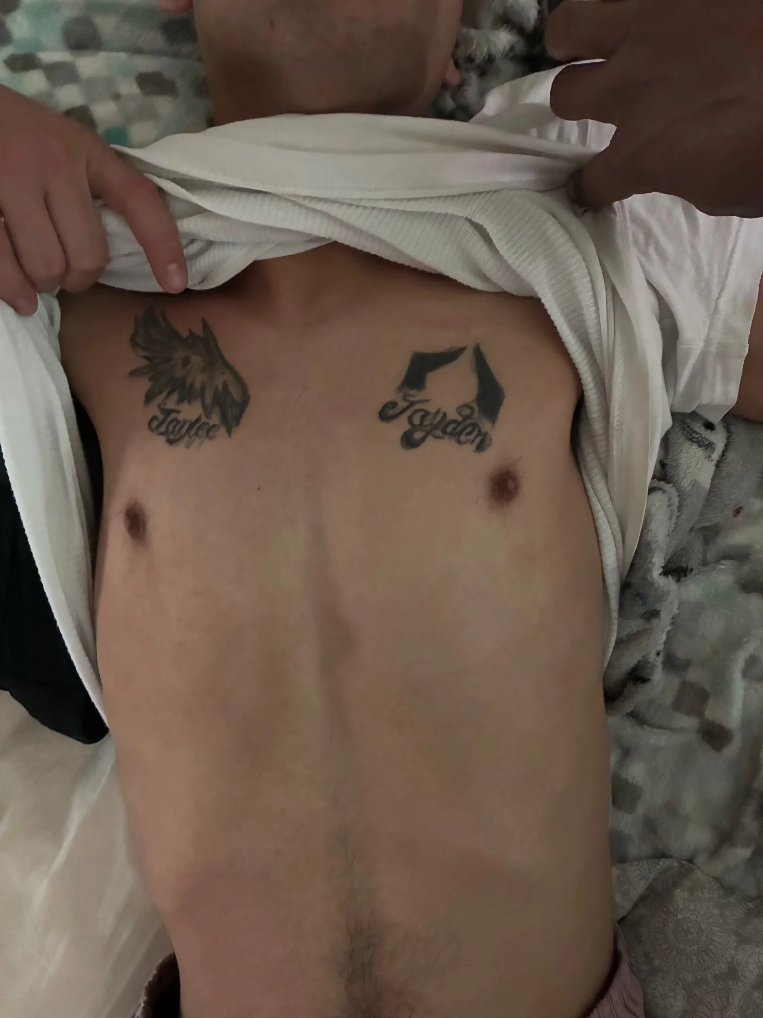 Black and grey name tattoos with eagle and diamond motifs on chest