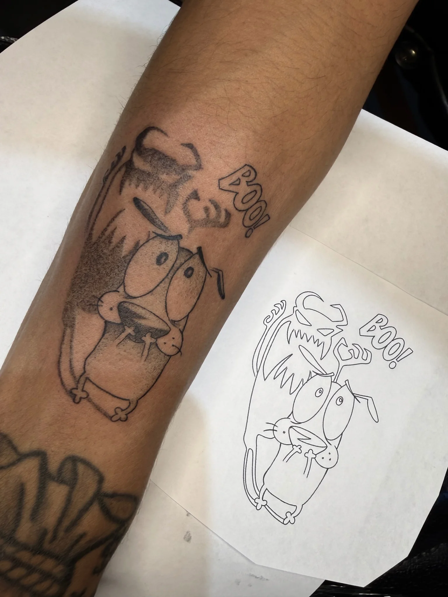 Black and grey Courage the Cowardly Dog illustrative tattoo on forearm