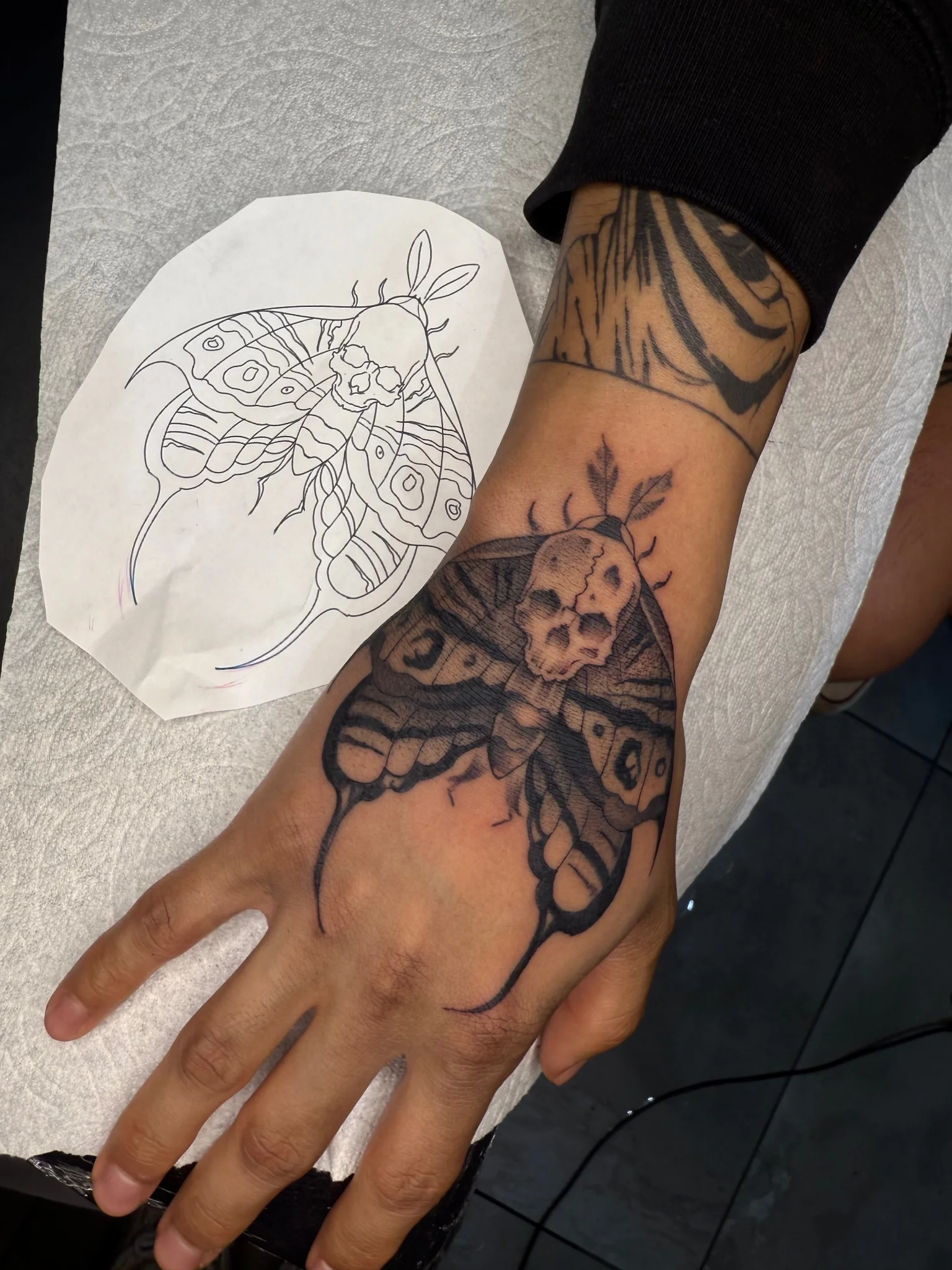 Black and grey death's head moth skull tattoo on hand