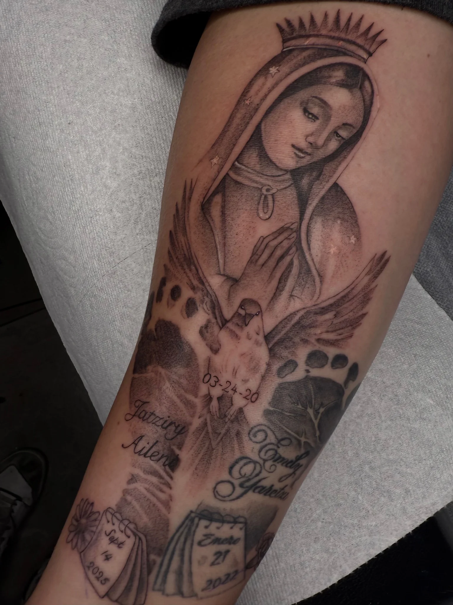 Black and grey Chicano sleeve with Virgin Mary, dove, and memorial script