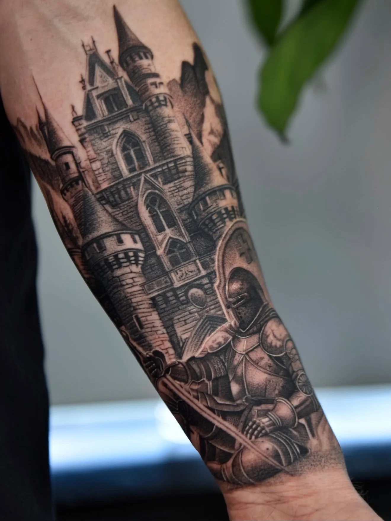 Black and grey realism knight and castle tattoo on forearm