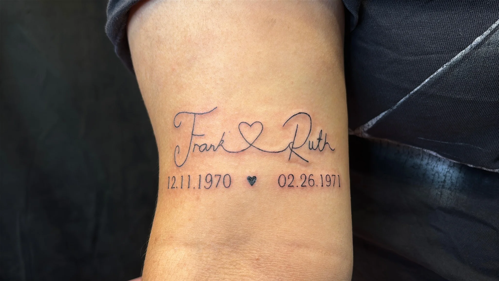 Fine line script name and date memorial tattoo on wrist