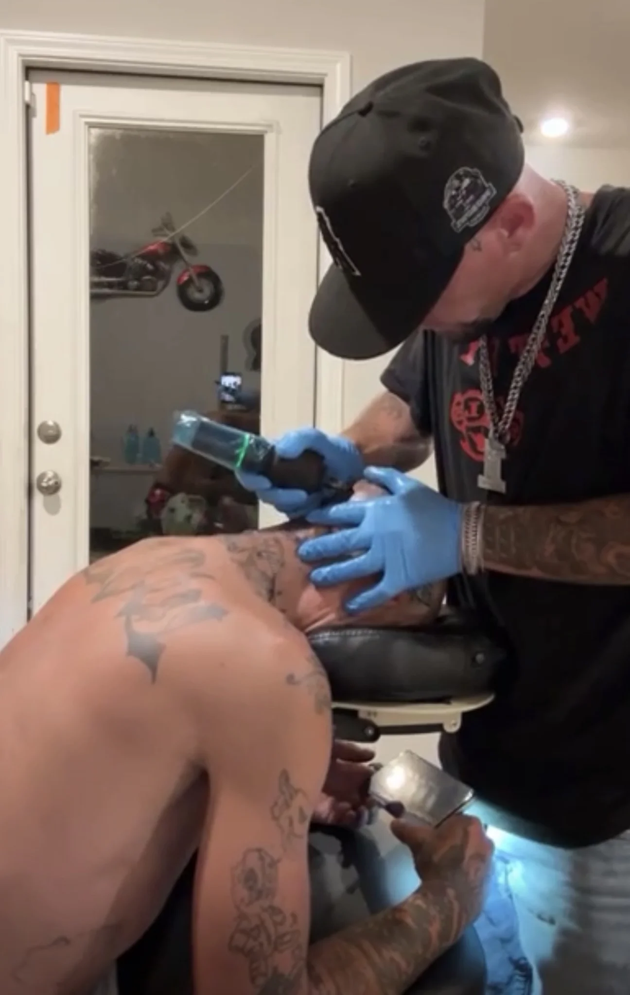 Black and grey tattoo being applied to client's chest area