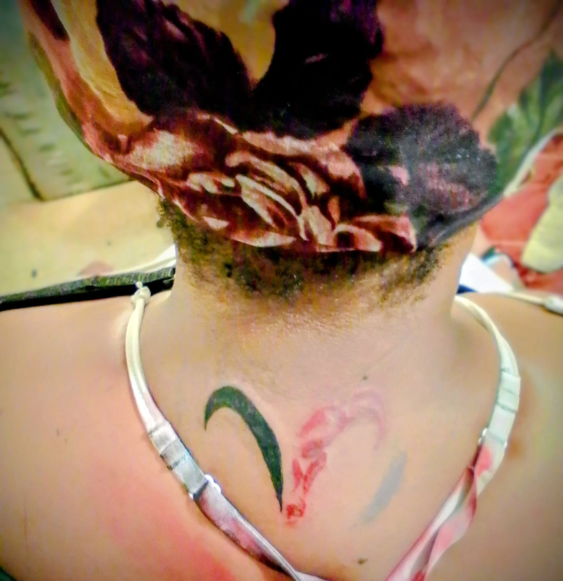 Minimalist heart outline tattoo on back of neck