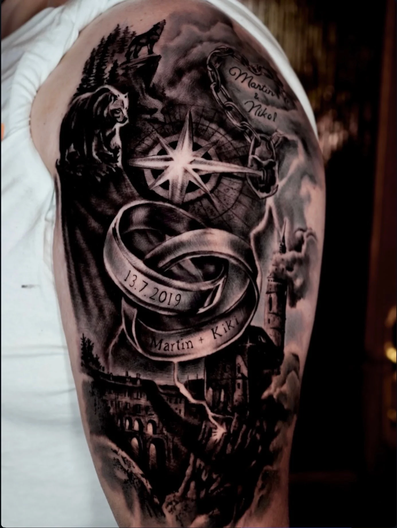 Black and grey realism sleeve with wedding rings, compass, and wolf