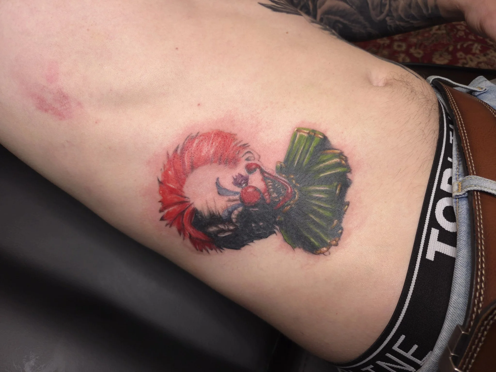 Color evil clown tattoo on hip area