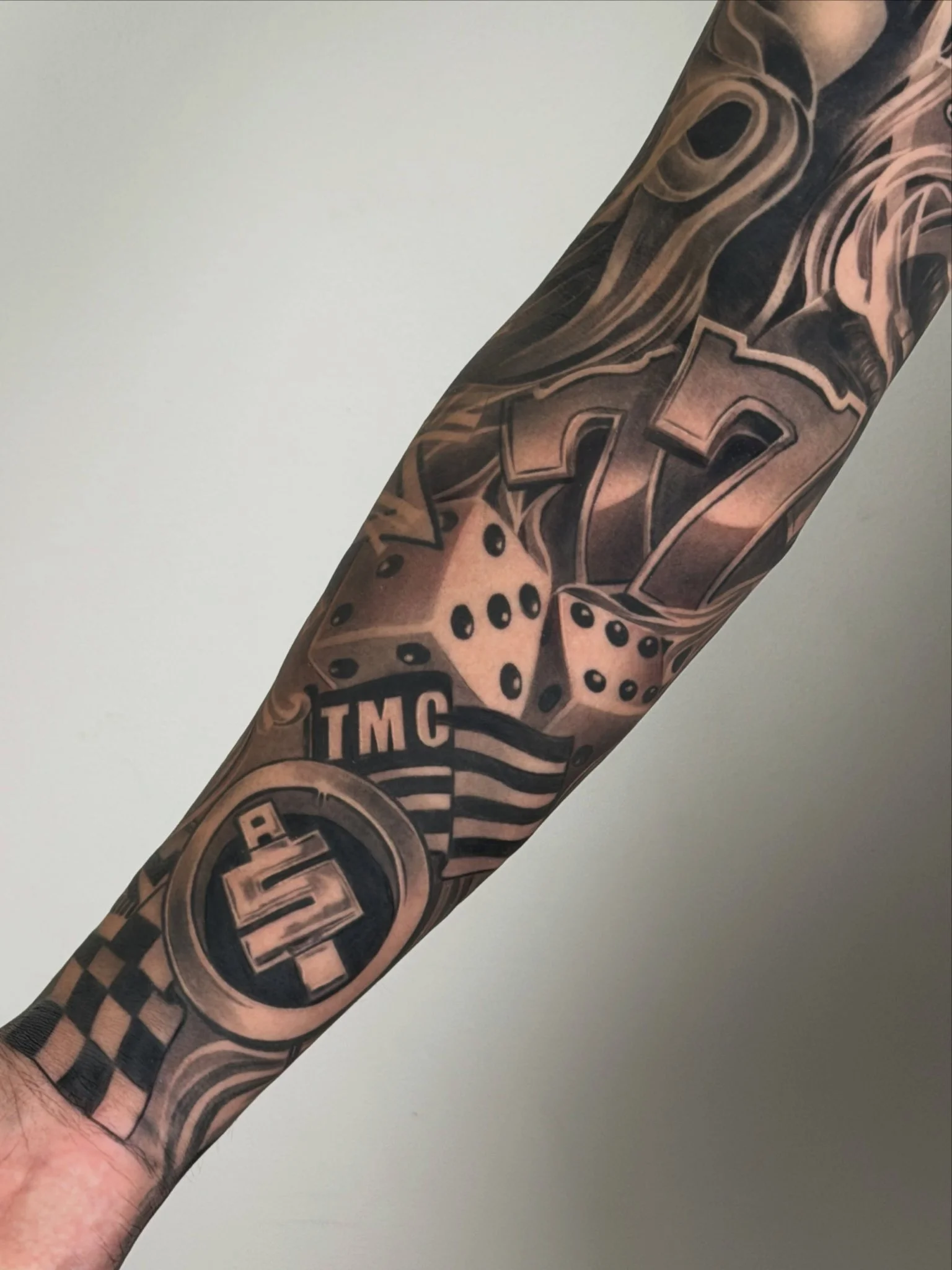 Black and grey casino themed sleeve tattoo on forearm