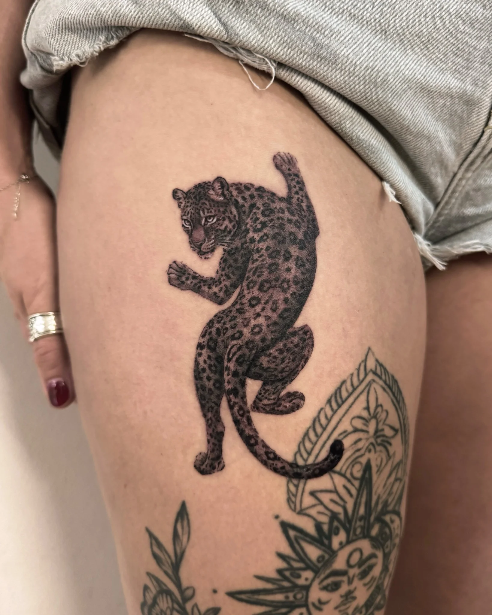 Black and grey realistic leopard tattoo on upper thigh