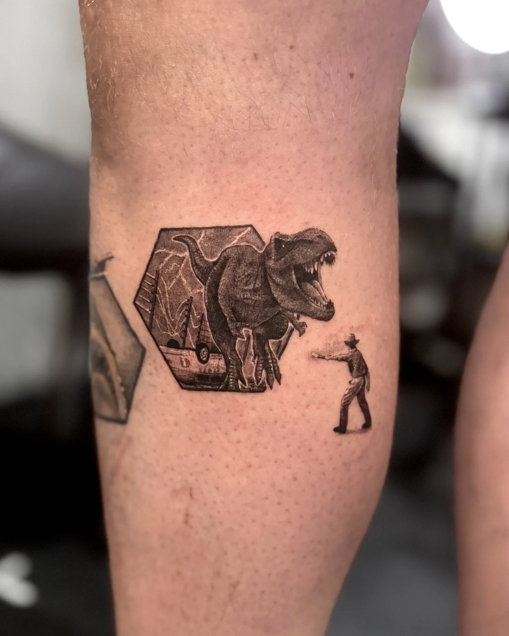 Black and grey Jurassic Park T-Rex realism tattoo on forearm