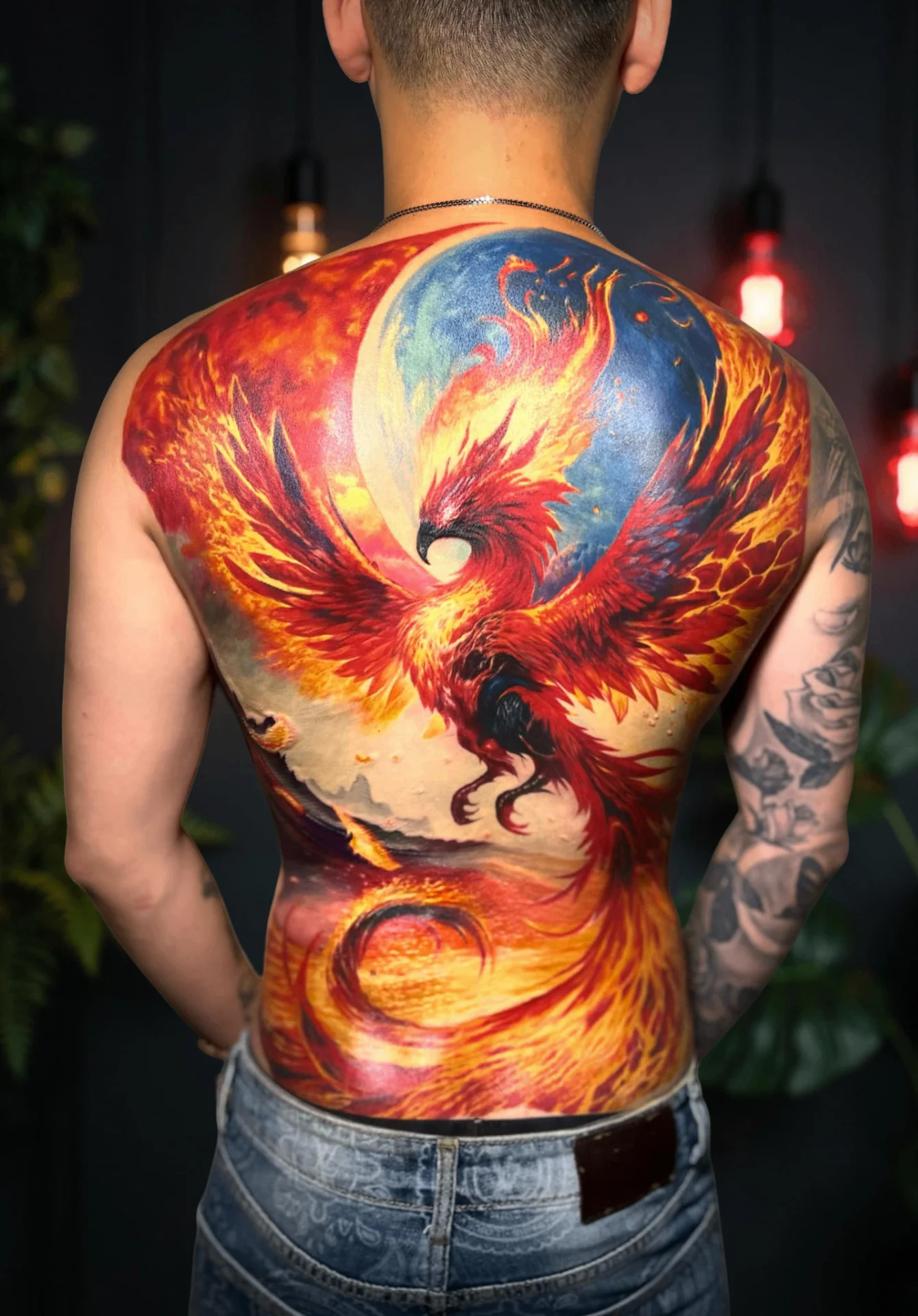 Vibrant color realism phoenix tattoo covering the full back
