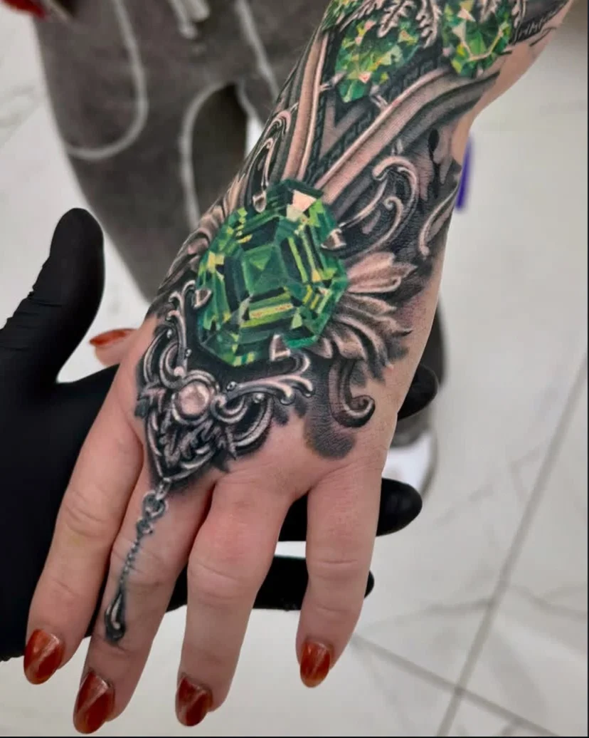 Color realism emerald gemstone with ornamental filigree on hand