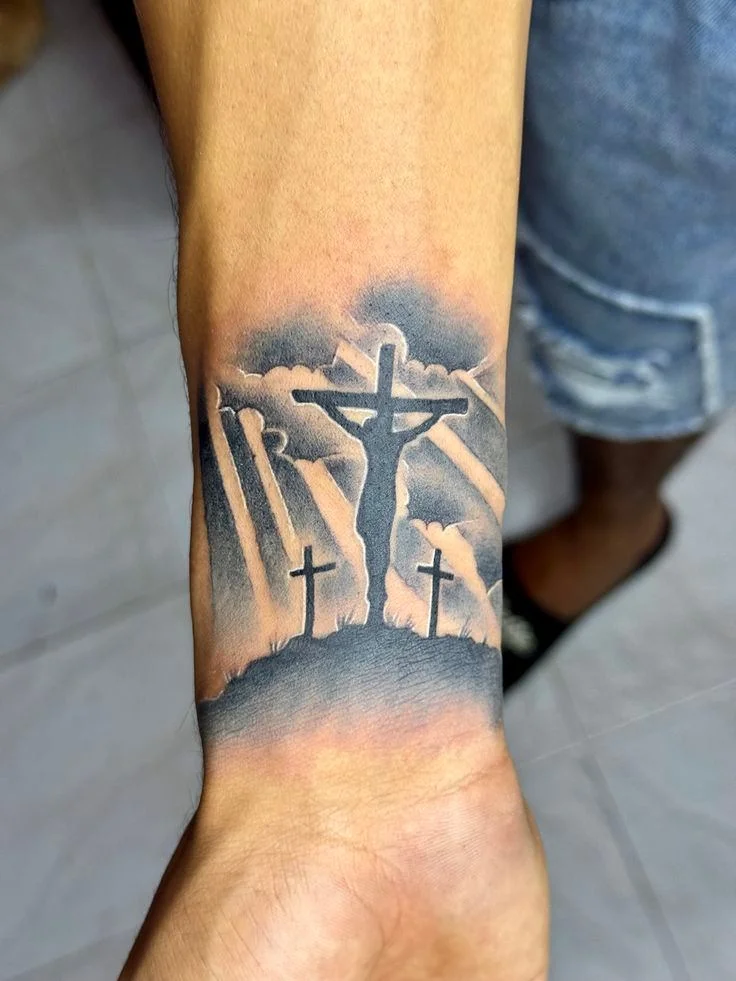 Black and grey crucifixion scene with three crosses on wrist