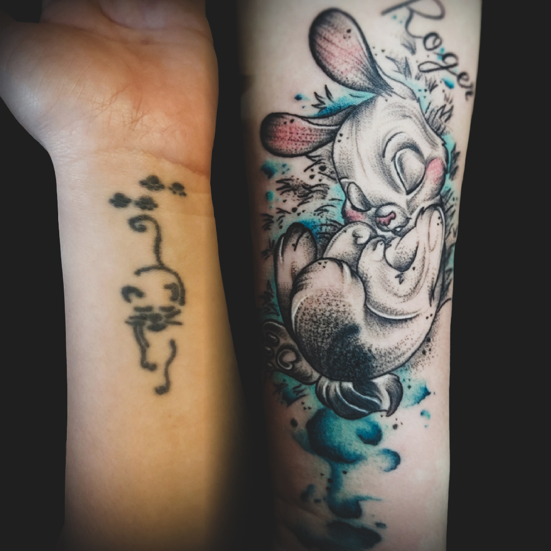 Neo-traditional rabbit tattoo with watercolor and floral elements on forearm