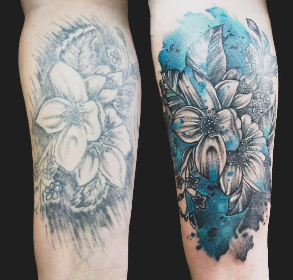 Watercolor floral tattoo with blue wash on forearm sleeve