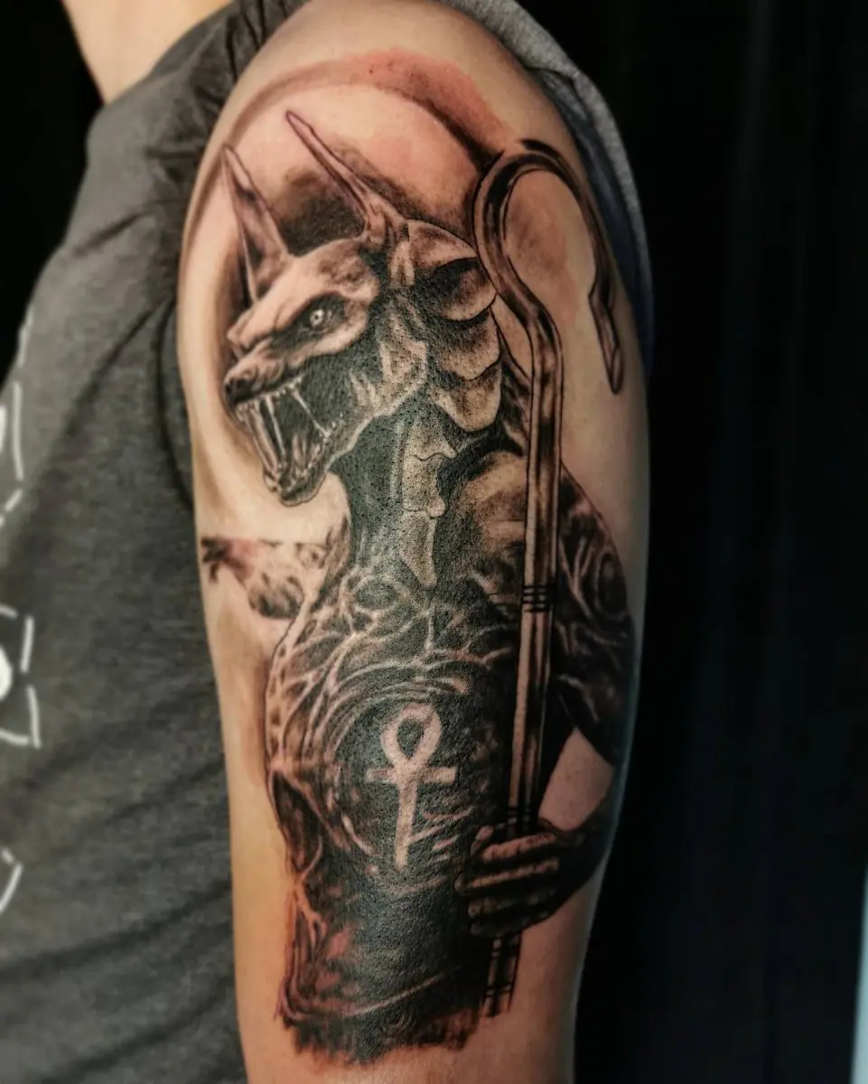 Black and grey realism deer and hunter portrait tattoo on upper arm