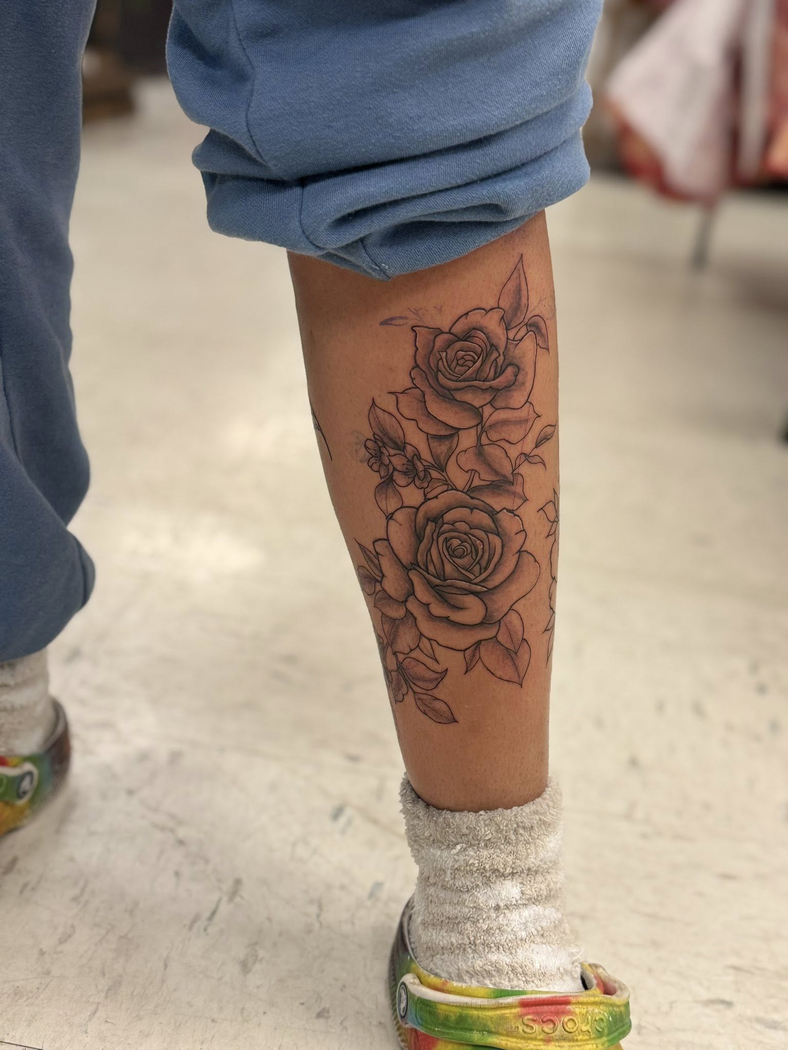 Black and grey realistic rose bouquet tattoo on calf