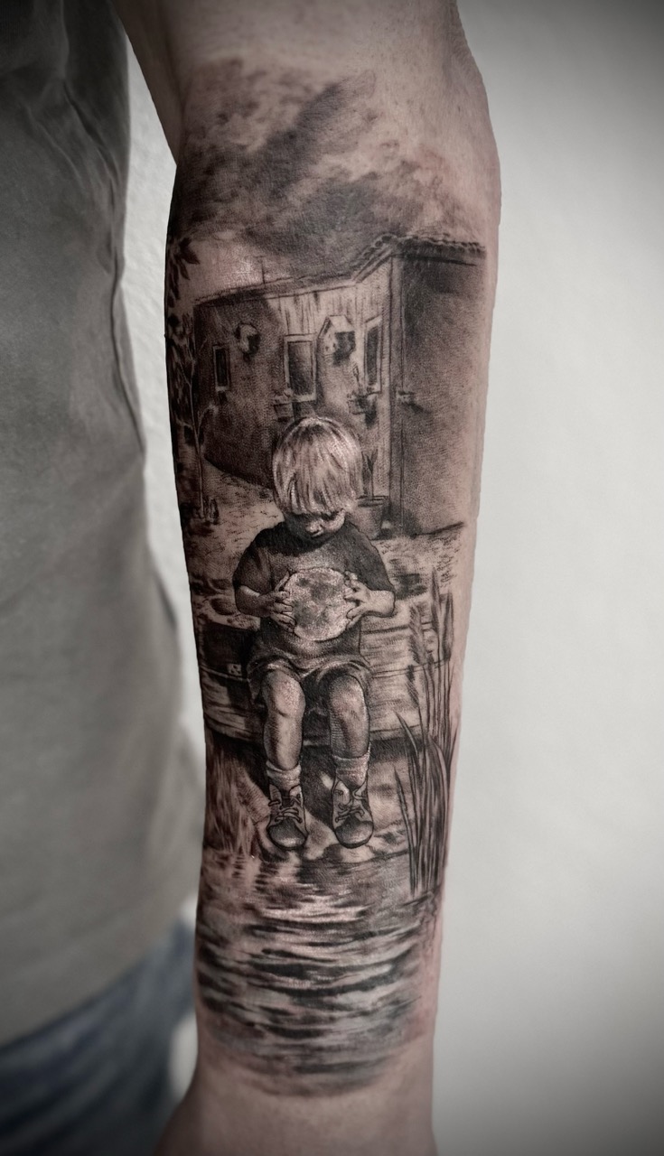 Black and grey realism portrait of child on forearm