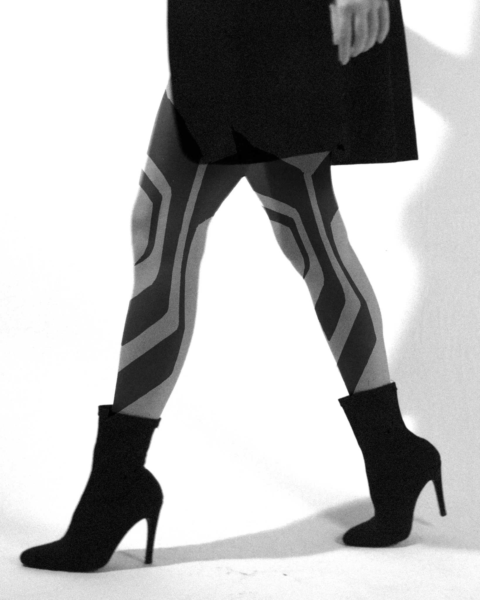 Geometric striped pattern tattoo covering both legs