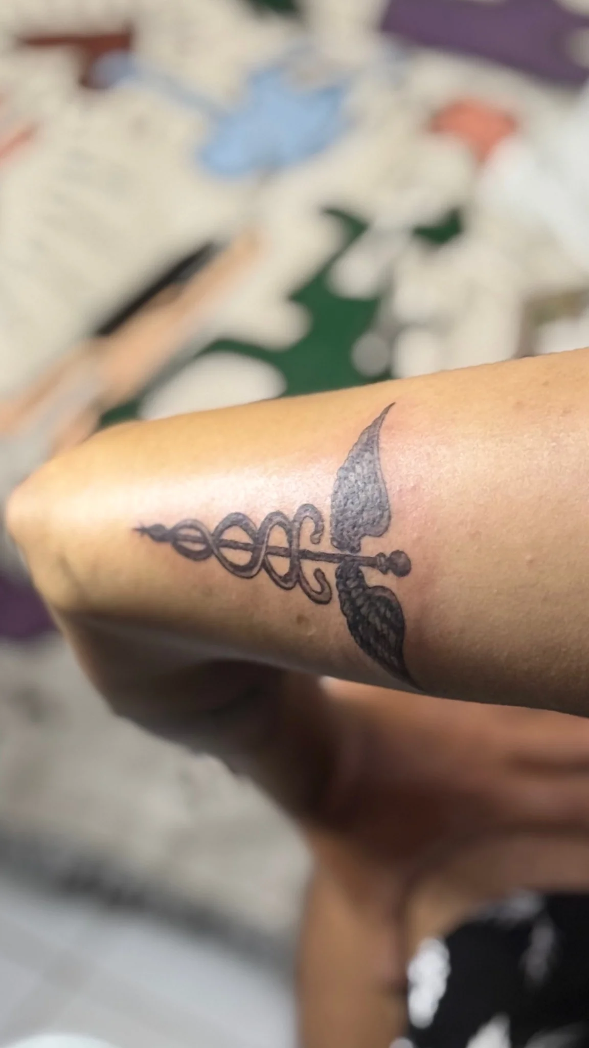Black and grey trident with serpent tattoo on forearm