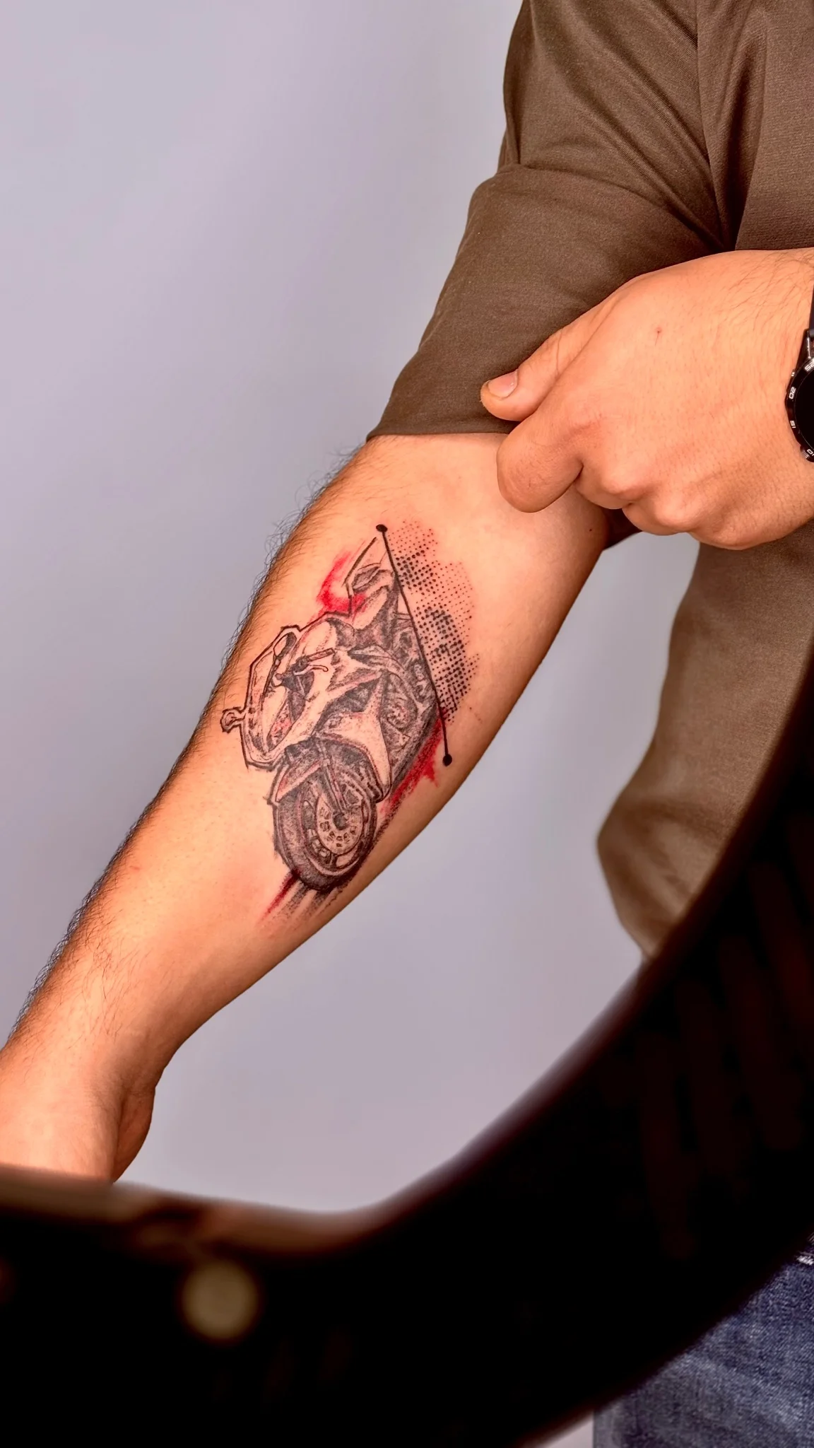 Black and grey anatomical heart tattoo with red accents on forearm